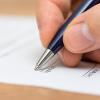 illustration of a hand holding a pen ready to sign a paper